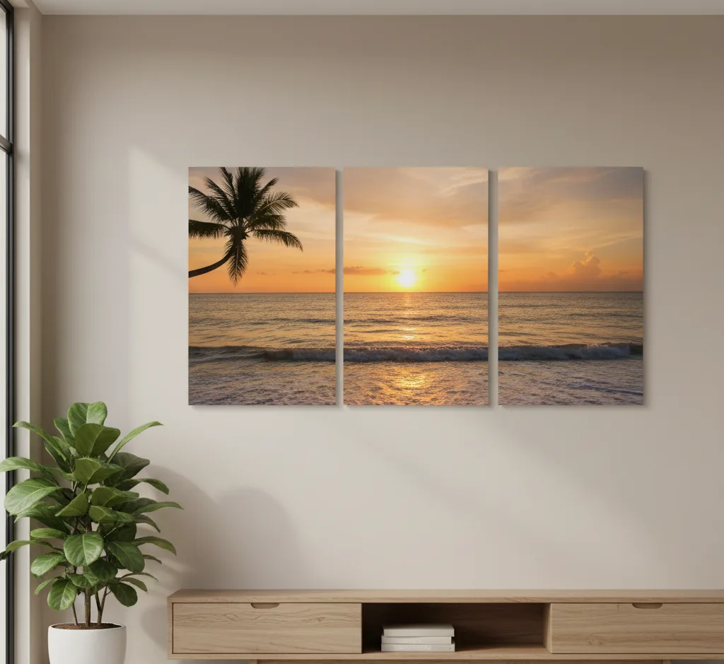 A modern room featuring a triptych canvas print on a light-colored wall, showing a continuous panoramic image of a vibrant tropical beach sunset with a palm tree on the left.